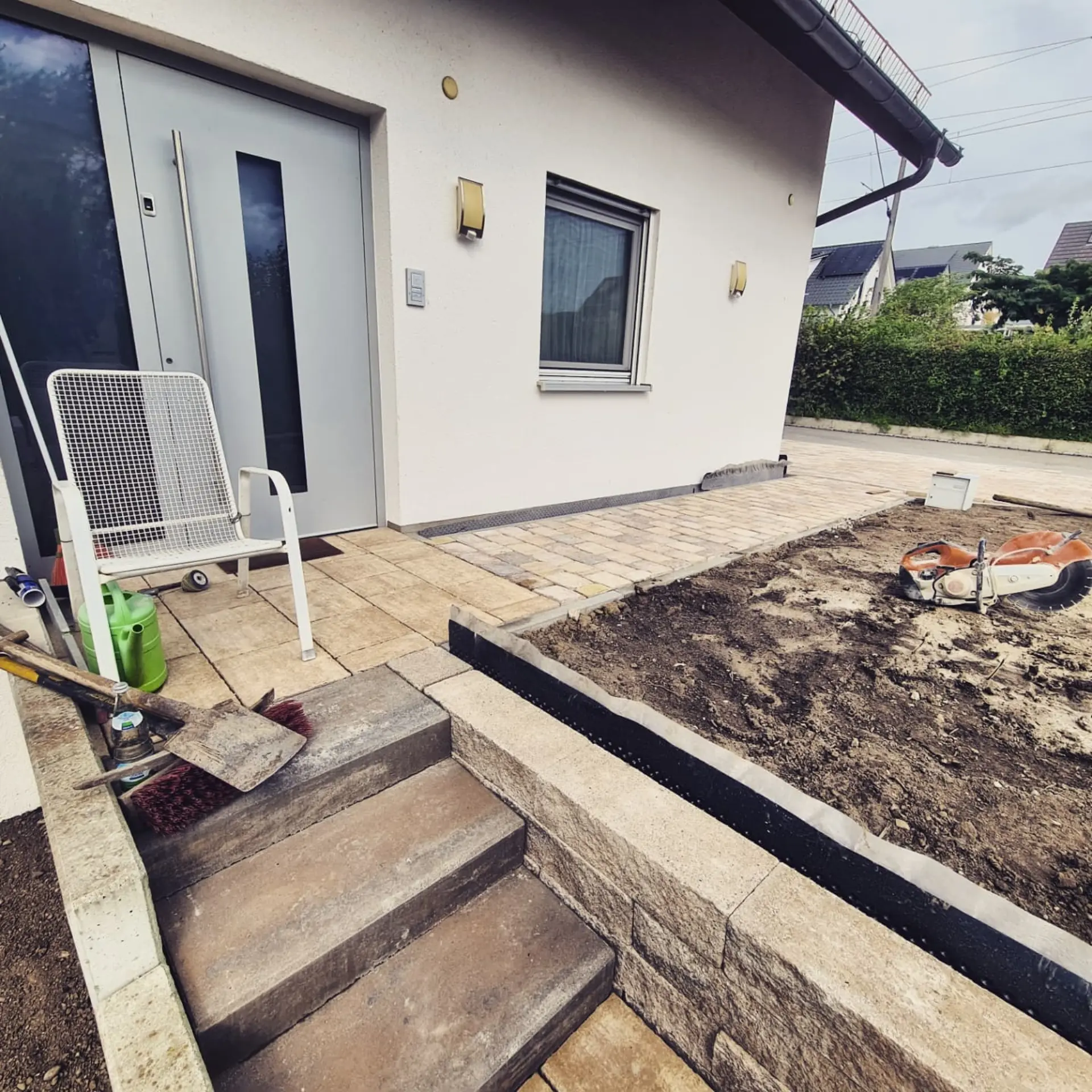 Pflasterarbeiten mit Natursteinmauer und Treppen im Eingangsbereich für Außenanlagen im Bodenseeraum
