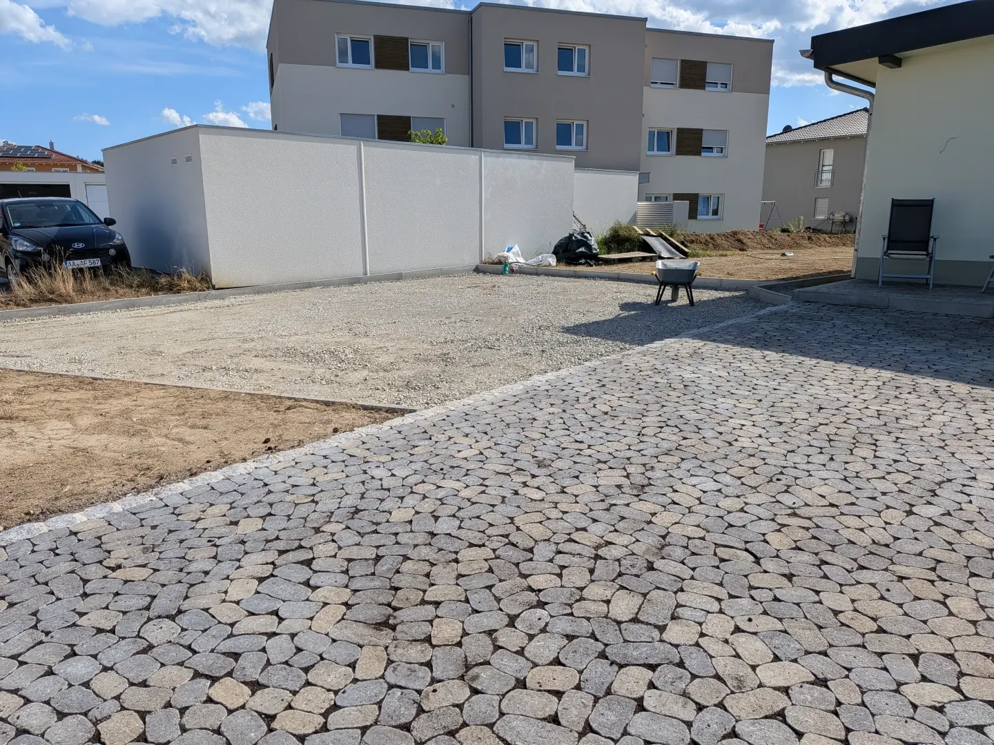 Gepflasterte Einfahrt mit Kiesparkplatz als Teil einer neu gestalteten Außenanlage im Kreis Konstanz